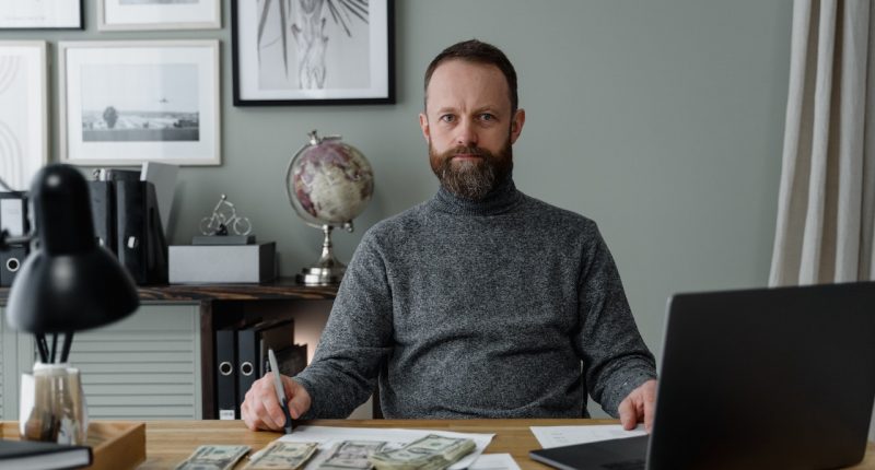 man-sitting-with-currency